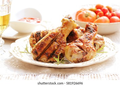 Dinner background. Grilled chicken drumsticks with rosemary.