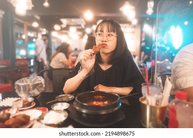 Dinner Couple Date At Indoor Restaurant Concept. Portrait Happy Smile Young Adult Asian Woman Holding Fried Chicken At Korean Meal. Foodie People Lifestyle.