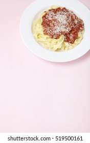 A Dinner Dish Of Spaghetti Bolognese On A Pastel Pink Background With Blank Space Below