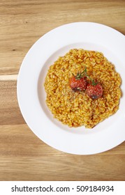 A Dinner Dish Of Tomato Risotto On A Wooden Kitchen Counter Background