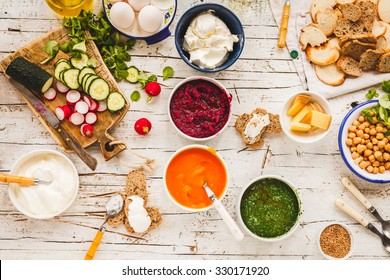 Dinner Food Table. Creamy Pumpkin, Beetroot, Spinach Soup With Chickpeas Dish - Homemade Recipe Of Cream Vegetarian Dish With Vegetables And Bread Slices On A Wooden Table. Rustic Style.