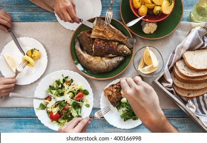 Dinner With Fried Fish, Potatoes And Fresh Salad