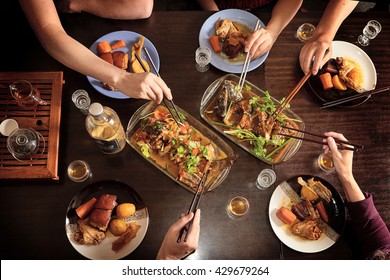 Dinner With Friends At The Table. View From Above. Chinese Food With Chopsticks. Fish, Meat, Pork, Potatoes.