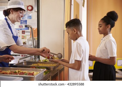 Dinner Lady Serving Kids In A School Cafeteria, Side View
