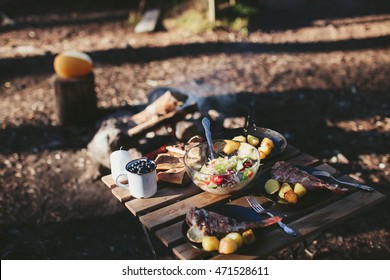 Dinner on the nature of the fire. Fish with potatoes and salad - Powered by Shutterstock