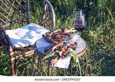 dinner outdoors, two plates of kebab and two glasses of red wine on the table - Powered by Shutterstock