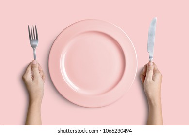 Dinner Place Setting. A Pink Plate With Silver Fork And Knife Isolated On Pink Background With Clipping Path