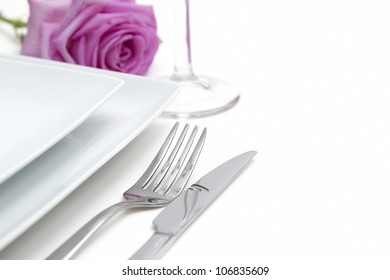 Dinner Place Setting. White China Plates With Pink Rose And Silver Knife And Fork