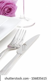 Dinner Place Setting. White China Plates With Fork, Knife, Glass And Pink Rose