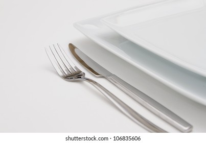 Dinner Place Setting. White Plates With Silver Fork And Knife