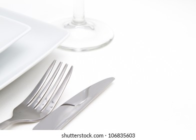 Dinner place setting. white square china plates with cutlery and glass - Powered by Shutterstock