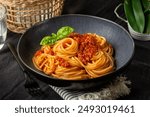 Dinner with a plate of Spaghetti with vegan bolognese sauce made from soya, tomato and vegetables. Vegetarian pasta. Light table surface.