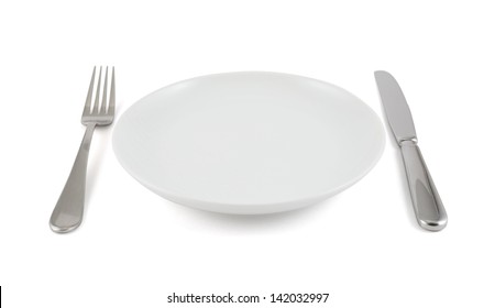 Dinner Is Served Composition: Table Knife, Fork Next To The Ceramic Empty Copyspace Plate Dish Isolated Over White Background