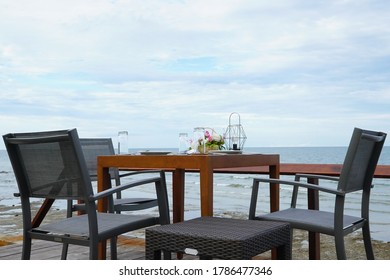 Dinner setup table on terrace nearby the sea with clear blue sky.