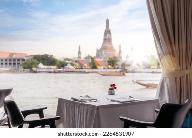 Dinner table in restaurant with Wat arun pagoda and temple back ground in Bangkok city, Thailand