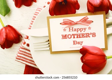 Dinner Table Setting With Mothers Day Message Card And Red Tulips