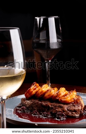 dinner table for two with two glasses of surf and turf white and red wine in focus