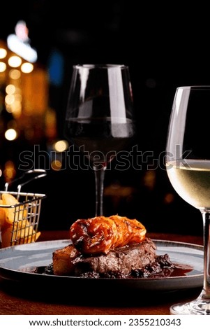 dinner table for two with two glasses of surf and turf white wine with blackberry jam in focus