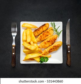 Dinner Table With White Plate, Chicken Fingers And French Fries In Top View