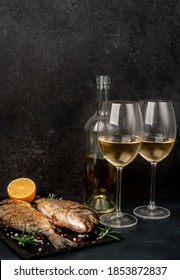 Dinner For Two. Grilled Dorado Fish With Spices And Glasses With White Wine On A Stone Background