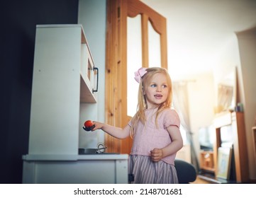 Dinners On Me Tonight. Shot Of An Adorable Little Girl Playing With A Toy Kitchen Set At Home.