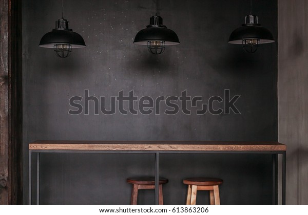 Dinning table set in loft style dining room with\
black lamps