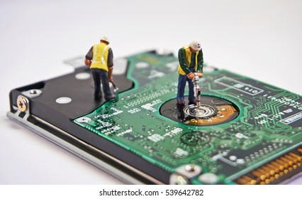 Diorama with circuit board and hard drive being maintained by two miniature workmen. Selective focus. IT/technology repair concept.         - Powered by Shutterstock