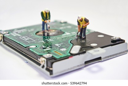 Diorama with circuit board and hard drive being maintained by two miniature workmen. Selective focus. IT/technology repair concept.         - Powered by Shutterstock