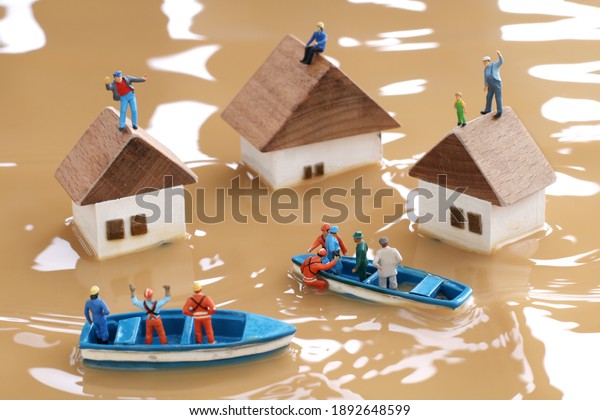 Diorama landscape of houses flooded by floods and\
people waiting for\
rescue