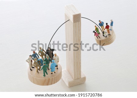 A diorama model that uses seesaws and balances to represent an aging society in which the population ratio of the elderly and young people changes 