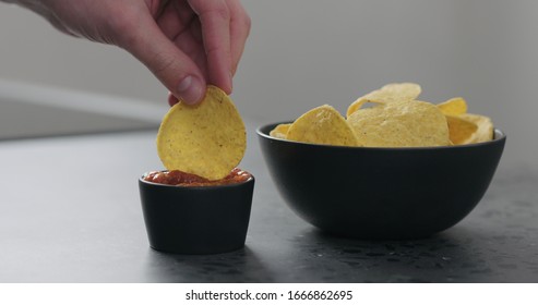 Dip Round Corn Chips In Salsa Closeup
