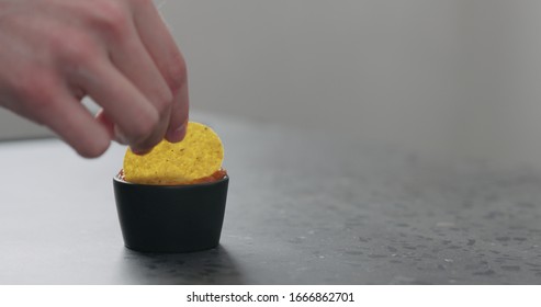 Dip Round Corn Chips In Salsa Closeup