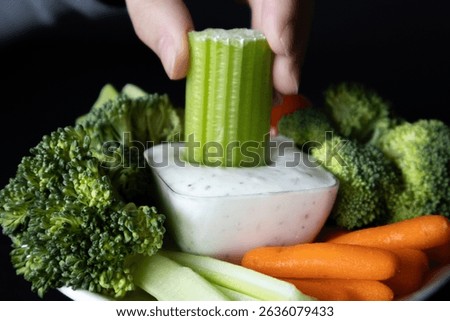 Dipping celery into ranch dressing