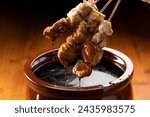 Dipping Chicken Thigh Skewers into Sauce Pot