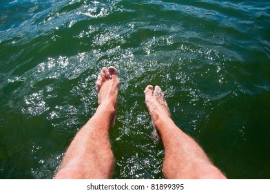 Dipping Feet In Water Off A Dock On A Hot Summer Day