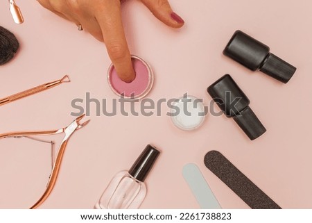 Dipping powder manicure tools on pink background. Woman dip her finger nail in the colorful powder Stockfoto © 