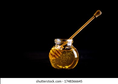 dipping a wooden stick for honey in liquid honey in glass jar, cooking with honey, sweets with honey - Powered by Shutterstock