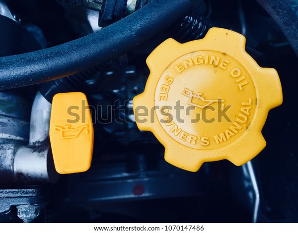 dipstick and oil\
cap of a car combustion\
engine