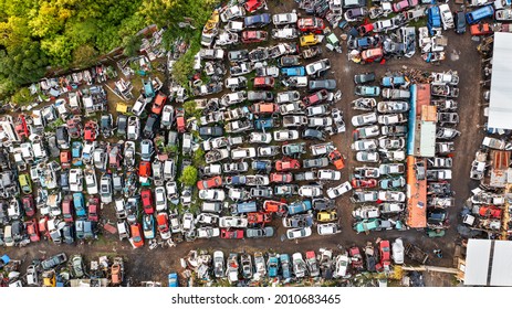 Direct Aerial Overhead View Of A Car Scrapyard, With Rows Of Wrecked Cars Lined Up To Be Used For Scrap Metal Or Spares.