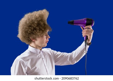 Direct Air Towards Yourself. Funny Student. Handsome Red-haired Man Holding A Hairdryer In His Hands. Loser. To Dry Hair. Beautiful Hairstyle. Humor. Shaggy Guy.