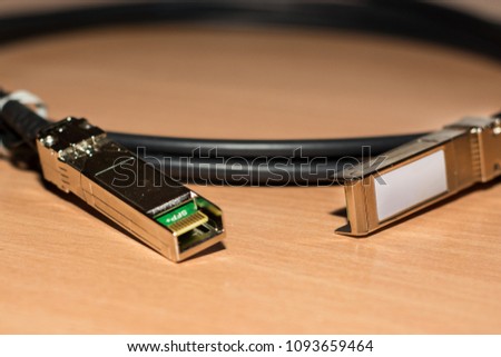 Direct attach copper cable for 10 Gb fast speed internet and network on wooden desk. Close up, selective focus
