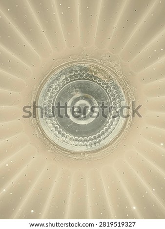 Direct bottom-up view of a circular concentric textured architectural element in neutral beige tones with subtle radial rings.