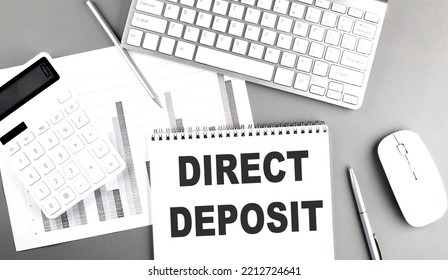 DIRECT DEPOSIT Text Written On Notebook On A Grey Background With Chart And Keyboard , Business Concept