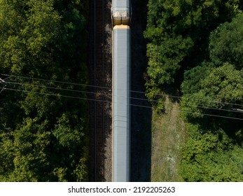 A Direct Overhead Aerial View Of An Autorack Freight Train Car While Travelling Through A Forest.