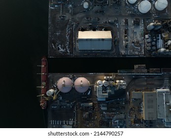 A Direct Overhead View Looking At A Waterfront Facility, And Port, As A Bulk Carrier Cargo Ship Is Seen Docked.