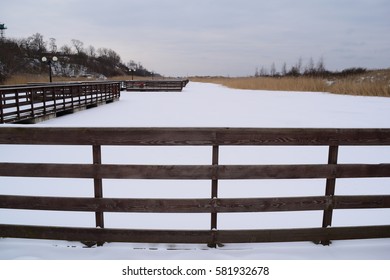 Direct view on the wooden planks of the boardwalk and nature in winter