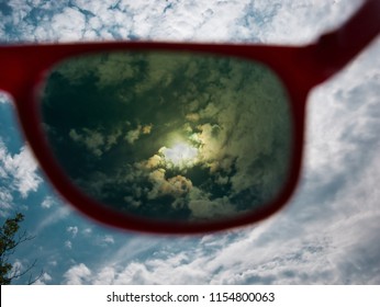 Direct View Of The Sun Through Red Sunglasses With UV Protection