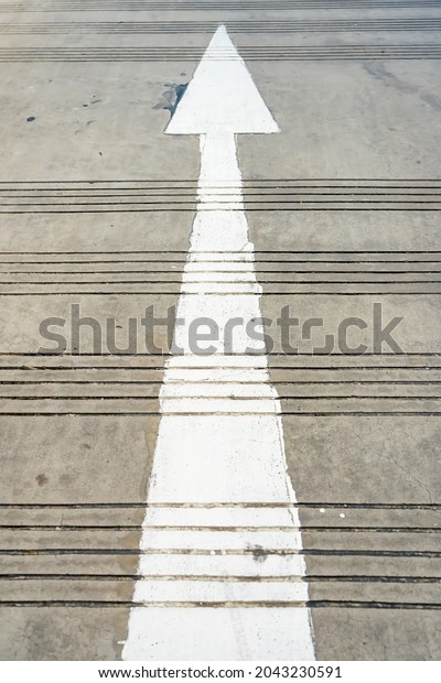 A direction arrow sign on the ground floor of the\
city street