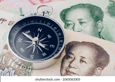 Direction Of China Financial And Economy Trade War, New Emerging Market High Growth Country Concept, Closed Up Of Compass On Chinese Yuan Banknotes On Table.