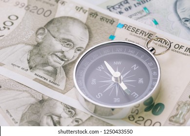 Direction Of India Financial And Economy, New Asia Developing And Emerging Market High Growth Country Concept, Closed Up Of Compass On Indian Rupee Banknotes On Table.